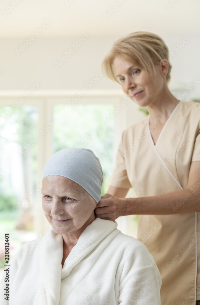Smiling caregiver and sick elderly woman with cancer Smiling caregiver and sick elderly woman with cancer