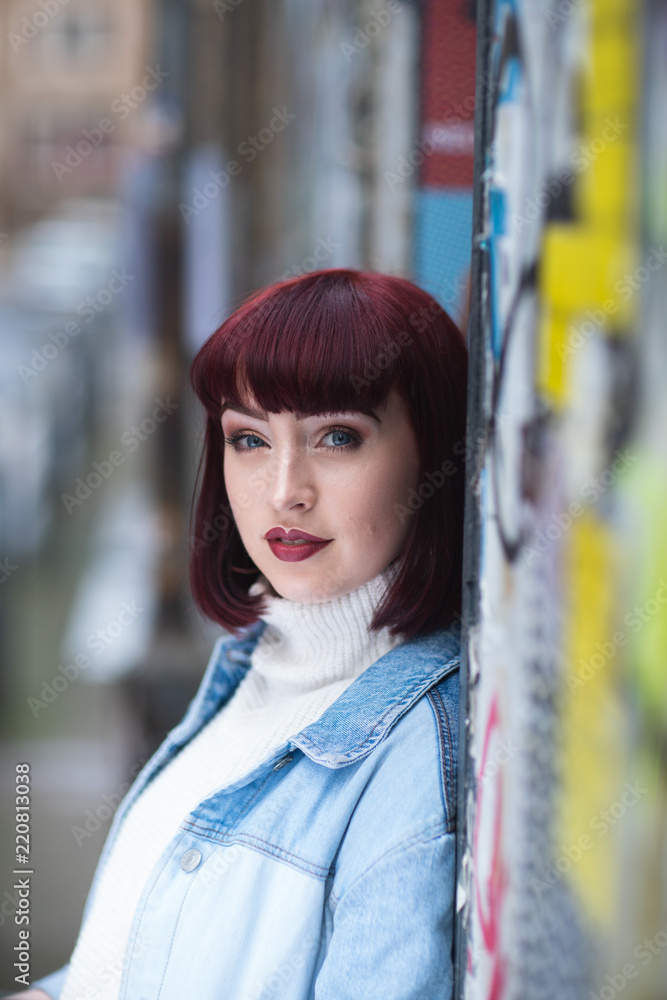 Portrait of young redhead with denim jacket and white turtle neck