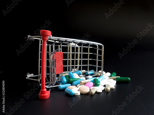 Foto shopping carts overthrow colorful medicine on black background