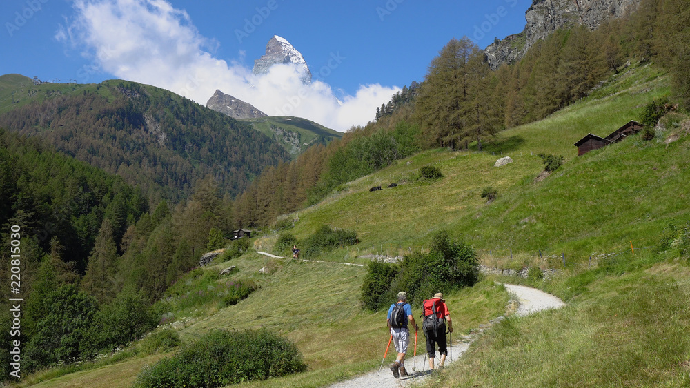 Two Elderly Hikers in Mountain Landscape With Iconic Matterhorn Mountain in Distance