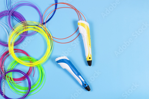 3d pens with colourful plastic filament on blue background photo