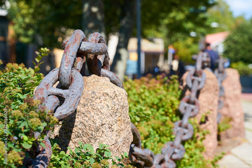 Naklejka premium Old metal rusty chain on the street with blurred background. 