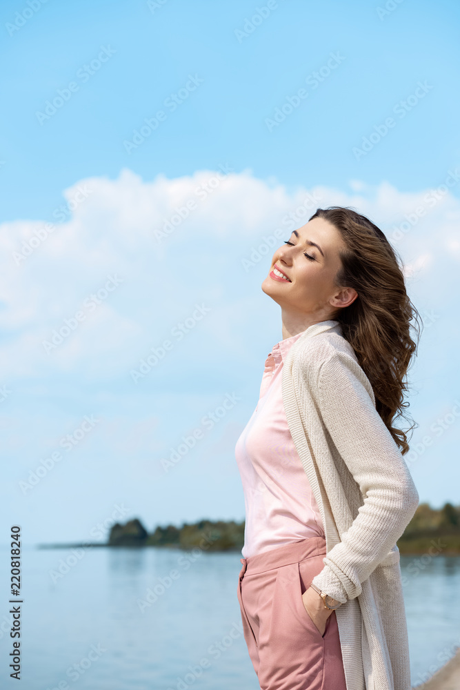 side view of beautiful smiling woman with river on background side view of beautiful smiling woman with river on background