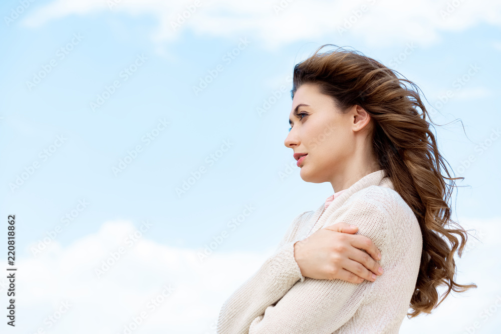 side view of beautiful pensive woman with blue cloudy sky on background side view of beautiful pensive woman with blue cloudy sky on background