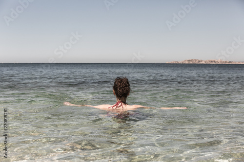 Femme se relaxant en mer et regardant l'horizon