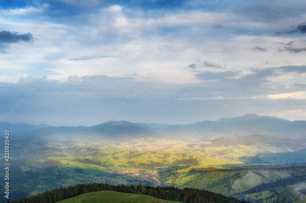 amazing  panoramic view with high mountain village on horizon and blue cloudy sky. summer (autumn) landscape. beautiful natural background