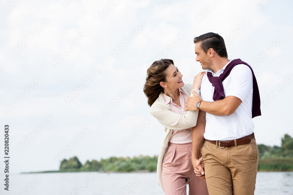portrait of happy couple looking at each other on beach portrait of happy couple looking at each other on beach