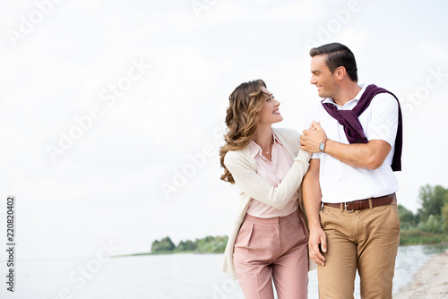 portrait of smiling couple looking at each other on sandy beach © LIGHTFIELD STUDIOS