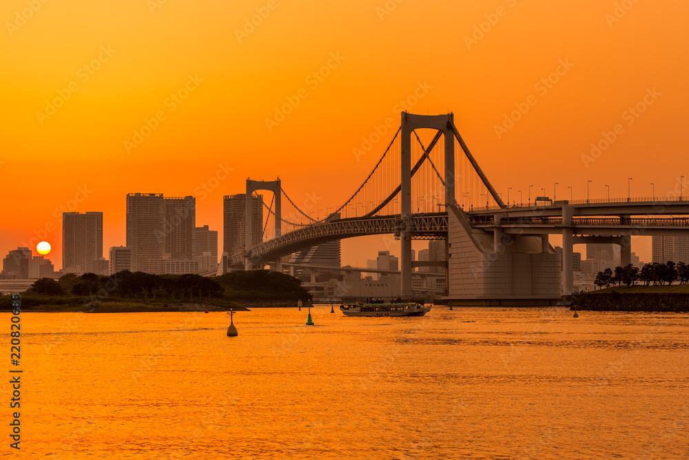 Fototapeta premium Tokyo skyline and rainbow bridge at sunset in Odaiba waterfront.