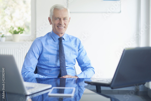 Successful businessman sitting at office desk