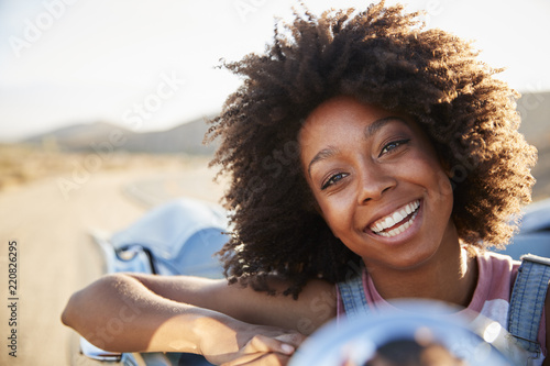 Portrait Of Woman Enjoying Road Trip In Open Top Classic Car