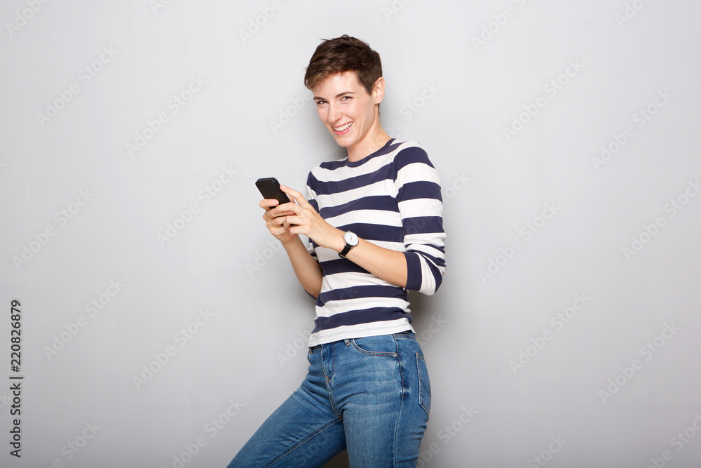 young woman smiling at text message on mobile phone young woman smiling at text message on mobile phone
