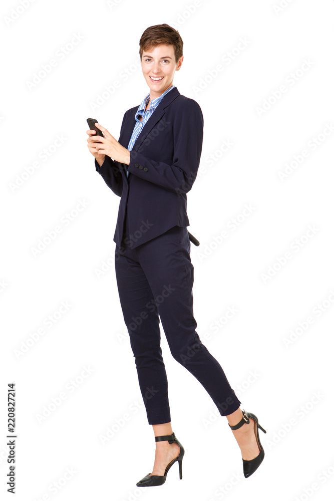 Full body businesswoman in formal suit smiling with mobile phone against isolated white background Full body businesswoman in formal suit smiling with mobile phone against isolated white background