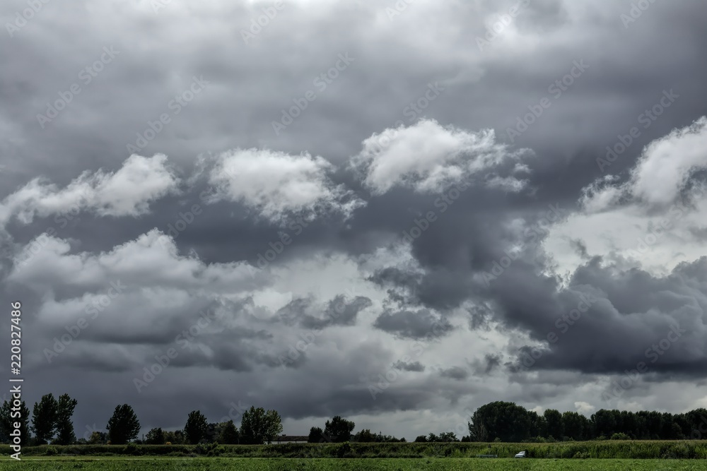 Obraz premium field landscape with clouds and thunderstorm in the sky