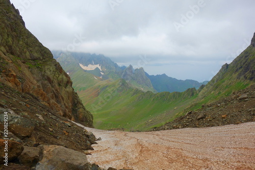 Hiking trail crossing a snowy Tobavarchkhili mountain pass in Caucasus Mountains in Georgia on a hike to Silver Lakes photo