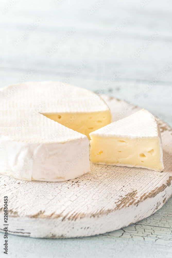 Camembert with capers on the wooden board