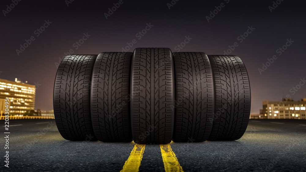 Five tires rolling on a street in a city at night Five tires rolling on a street in a city at night