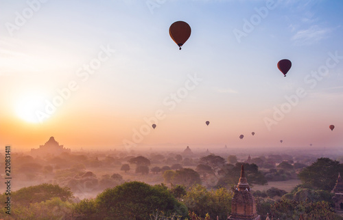  plain of Bagan Myanmar (Burma) is filled with the Golden light of the sun with the silhouettes of balloons