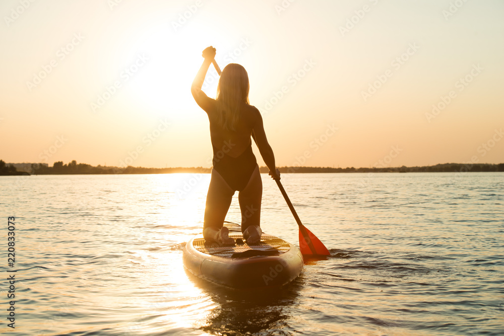 Young sexy woman swimming on stand up paddle board.Water sports , active lifestyle.
