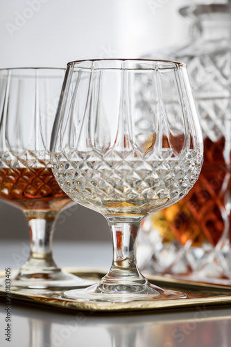 Weinbrand in Bleikristall Flasche mit Schwenker Gläser auf Metall Tablett photo