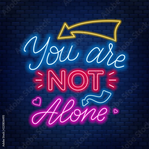 Neon lettering you're not alone. Motivational quote.