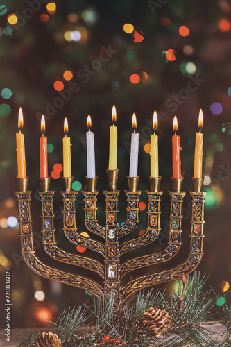 Burning hanukkah candles in a menorah on colorful candles from a menorah