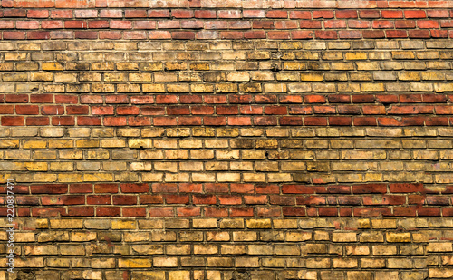 The texture of red and yellow brick on the old building. Close-up. The background is building.