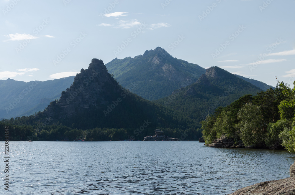 Beautiful mountains covered with pine forest on the shore of the lake.