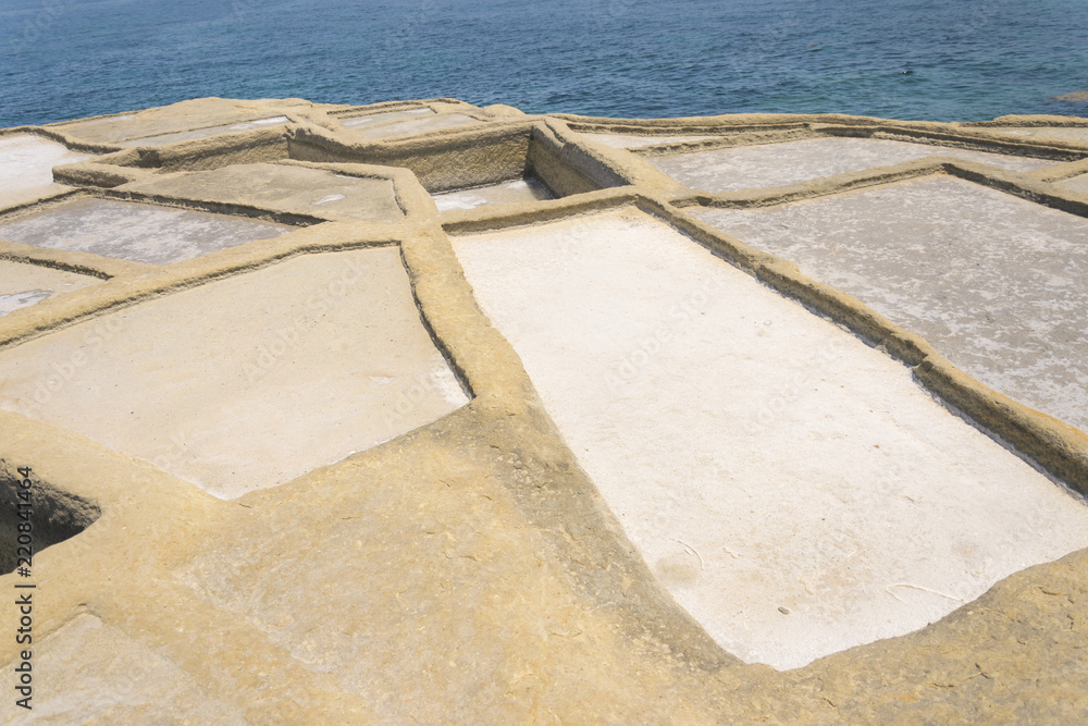 Traditional Maltese salt evaporation in city Zebbug, Gozo / Malta. Square salt pans is former method of salt production on site next battery Qolla l-Bajda. Traditional Maltese salt evaporation in city Zebbug, Gozo / Malta. Square salt pans is former method of salt production on site next battery Qolla l-Bajda.