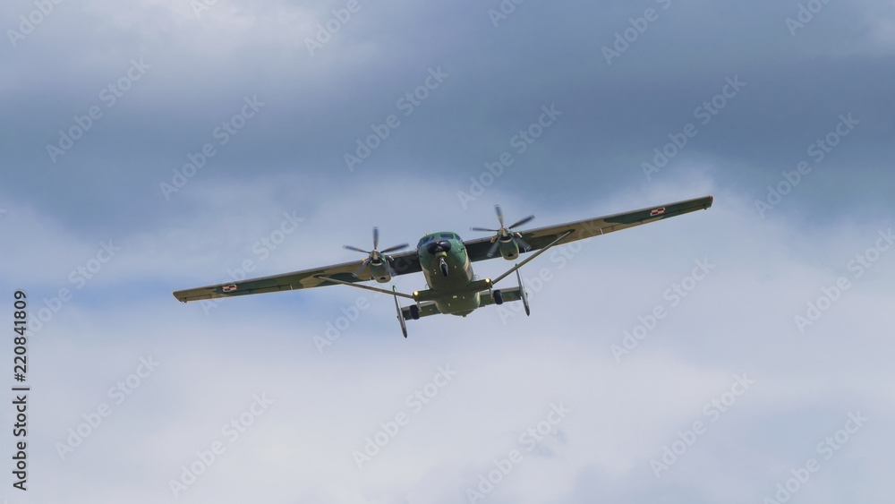 Double engine army camouflage propeller plane on air show in Krakow. Retro military defence airplane flying on dark sky, similar used during world war. Double engine army camouflage propeller plane on air show in Krakow. Retro military defence airplane flying on dark sky, similar used during world war.