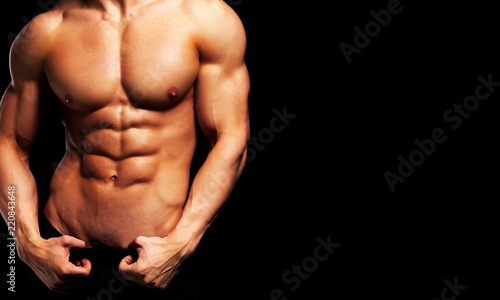 Close up of perfect male body isolated on black background with