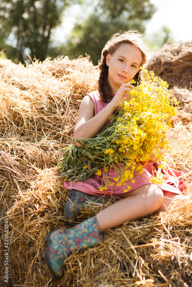 Cute little smiling girl with a bouquet of flowers on a farm in the summer. Cute little smiling girl with a bouquet of flowers on a farm in the summer.