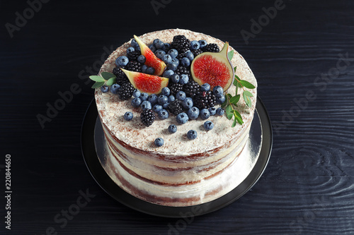 Delicious homemade cake with fresh berries on dark wooden table