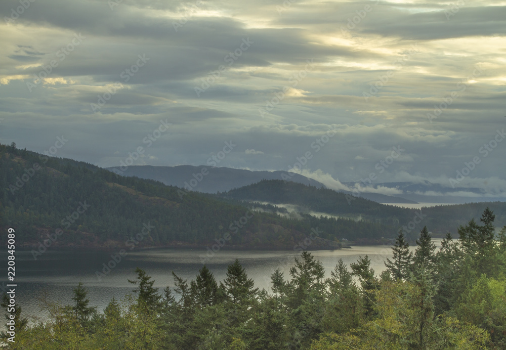 Naklejka premium Cloudy sky over mountains with low hanging clouds in the distance