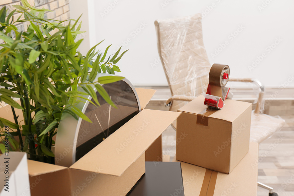 Moving box with office stuff on table indoors, closeup Moving box with office stuff on table indoors, closeup