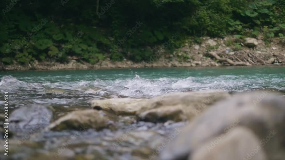 Water stream of mountain river quickly flowing on stones. Clear water in creek Water stream of mountain river quickly flowing on stones. Clear water in creek