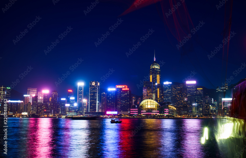 Hong Kong cityscape view of modern buildings over water from Victoria harbor at night