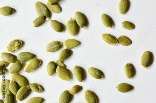 Tasty raw green pumpkin seeds on the white table