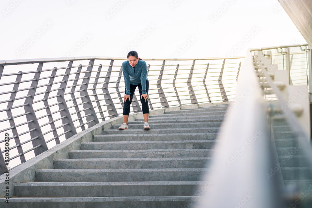 Tired runner taking rest on the staircase outdoors