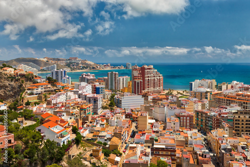 Beautiful above view of the vacation area of Cullera, Spain, showing the city and the coastline with a bright blue sky and white clouds photo