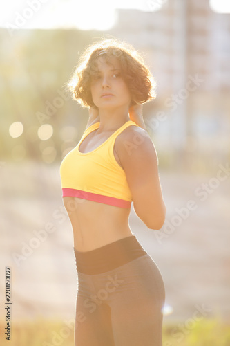 Beautiful young woman doung fitness exercises outdoor photo