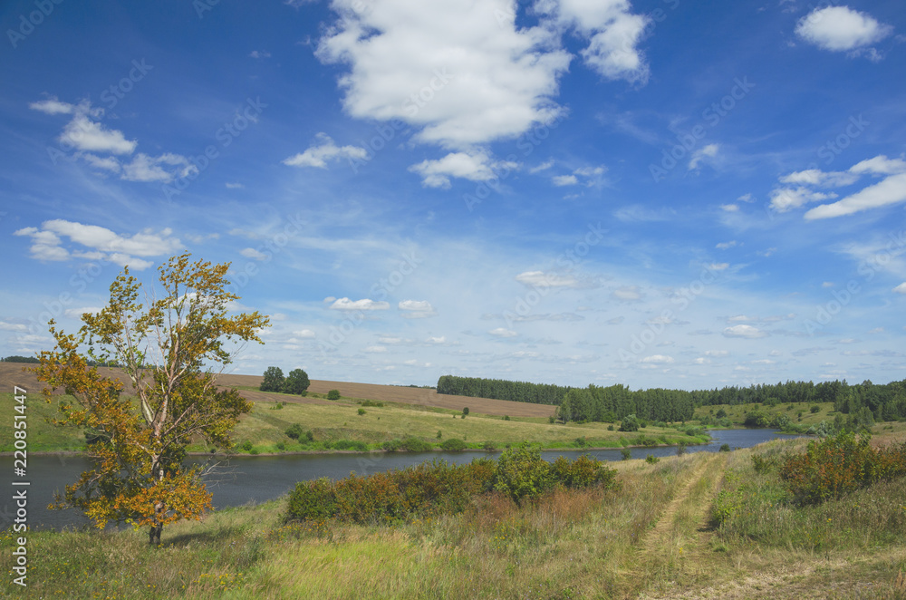 Sunny summer landscape with river,fields,green hills and beautiful clouds in blue sky..Tula region,Russia. 