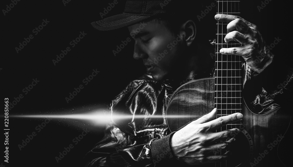 Fototapeta premium black and white portrait of asian handsome male musician posing on acoustic guitar