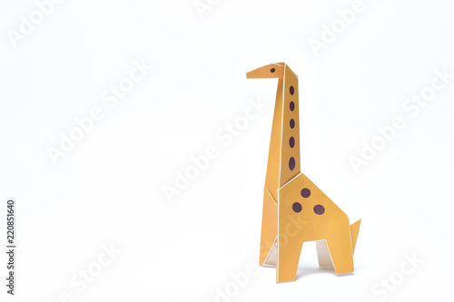 Photography A yellow origami giraffe stands tall on a white background