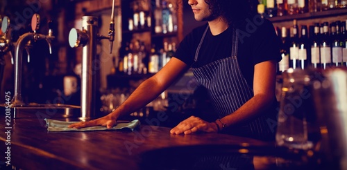 Young waiter cleaning a counter photo