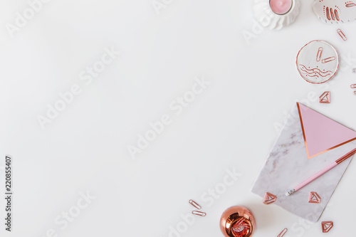 Flatlay of desk table. Workspace with modrn pink and marble notebooks and decorations on white background.