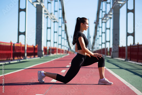 Attractive sporty girl stretching legs before run. Space for text