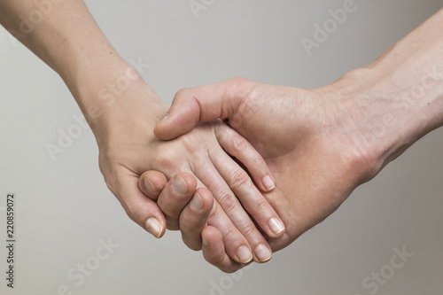 Loving man and woman hold hands on a white background. 