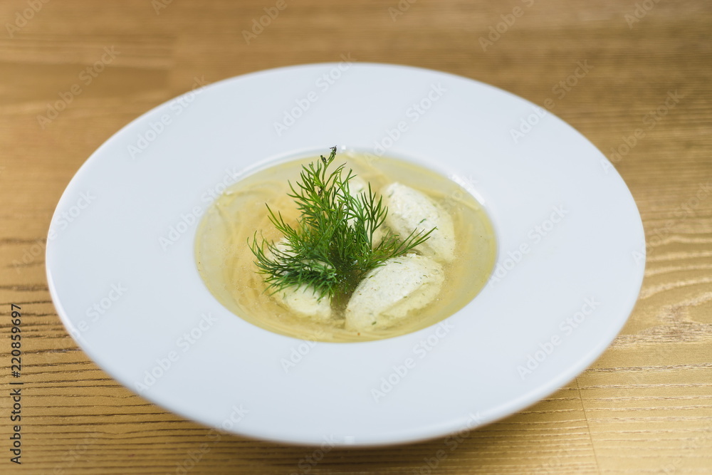 soup with meatballs, noodles and greens in a white plate soup with meatballs, noodles and greens in a white plate