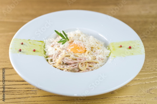 Spaghetti carbonara with bacon and egg on a white plate
